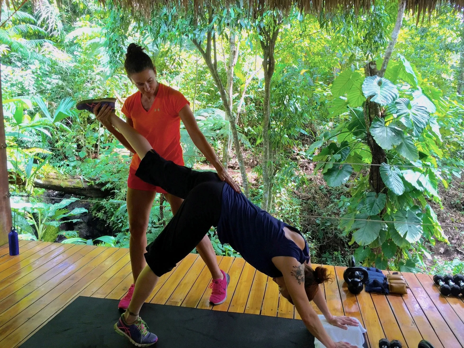 Terri Walsh coaching a private client through a stretch on the jungle training deck