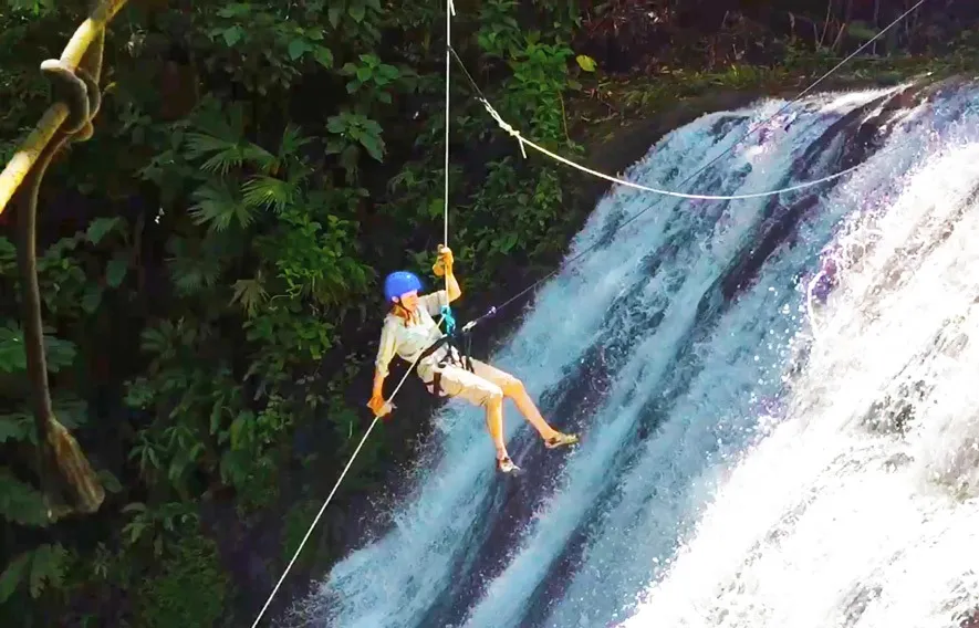 Guest rappelling down a waterfall on a fitness excursion day